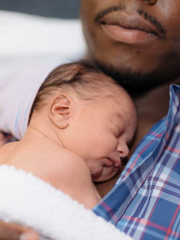 Papa en peau à peau avec son nouveau-né endormi