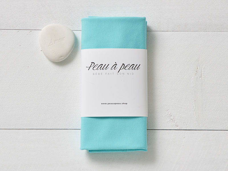 Bandeau de couleur céleste de la collection Peau à Peau présenté dans un emballage simple