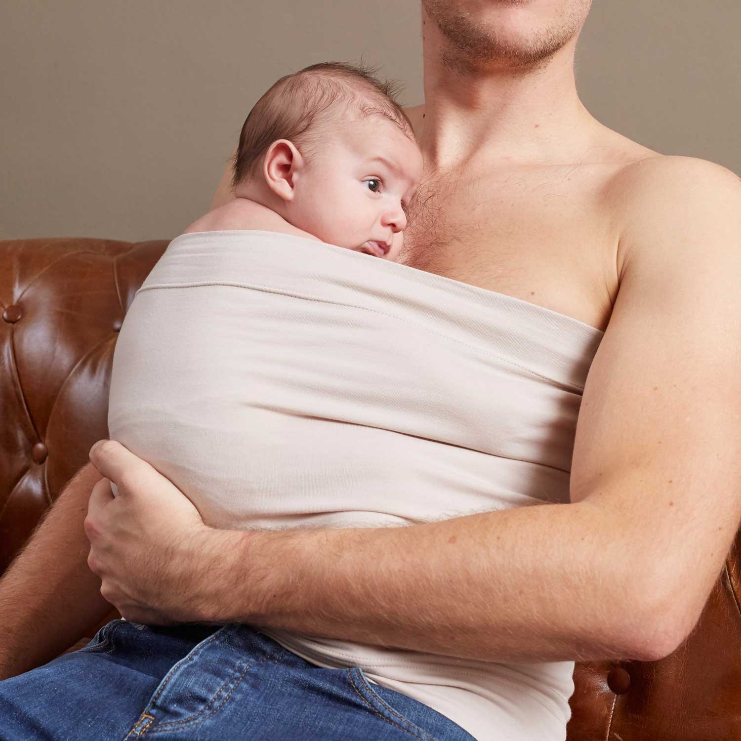 Papa portant son nouveau-né en peau à peau dans le bandeau